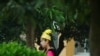 2021年4月13日，一名身着维吾尔族服装的女子站在广西钦州环球电子股份有限公司的厂区内（路透社）。