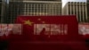 资料照：香港主权移交26周年纪念期间，中国国旗和香港区旗高挂香港街道大楼，旗帜后有行人走过天桥。（美联社，2023年6月27日）