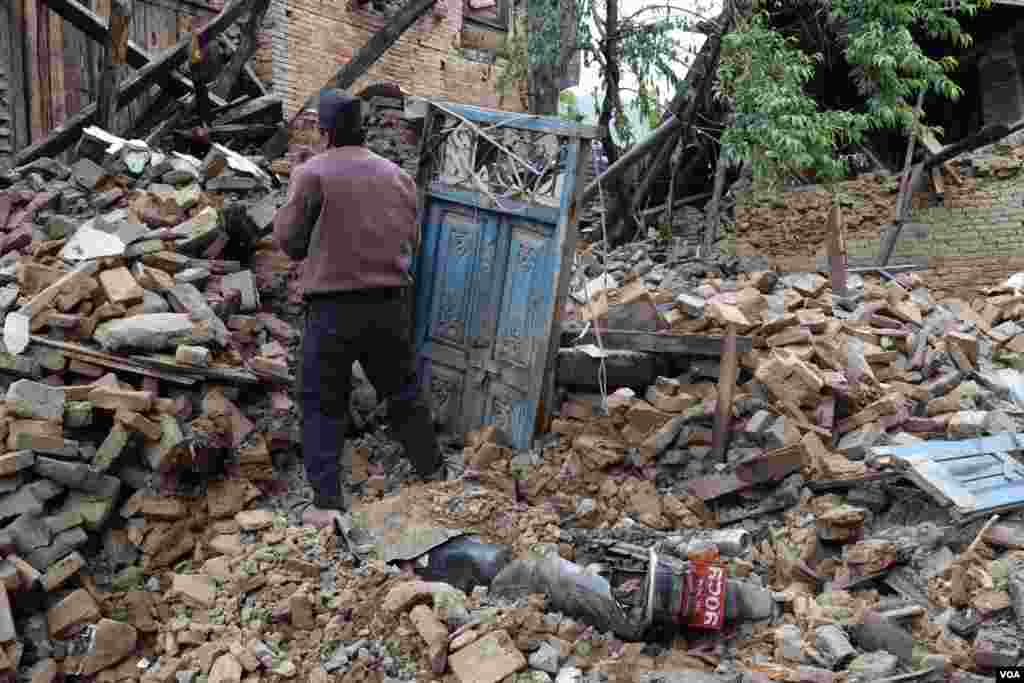 An earthquake survivor tries to salvage anything of value from his destroyed home, Sankhu, Nepal, April 29, 2015. (Steve Herman/VOA)