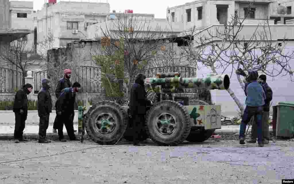 Fighters from the Amjad al-Islam brigades stand near an improvised artillery weapon in eastern al-Ghouta, near Damascus, Feb. 4, 2014.