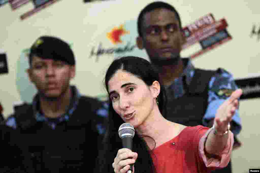 Yoani Sánchez tuvo que ser escoltada por guardias de seguridad mientras habla con simpatizantes y manifestantes al mismo tiempo durante una reunión con la prensa, donde señaló que esperaba que se produjeran este tipo de incidentes donde grupos socialistas la tildaron de "mercenaria".