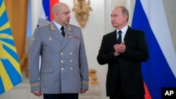 FILE - Russian President Vladimir Putin applauds Col. Gen. Sergei Surovikin during an awards ceremony for troops who fought in Syria, in the Kremlin, in Moscow, Dec. 28, 2017. Putin says Russia's action in Syria has demonstrated the power of the nation's modernized military to the world.