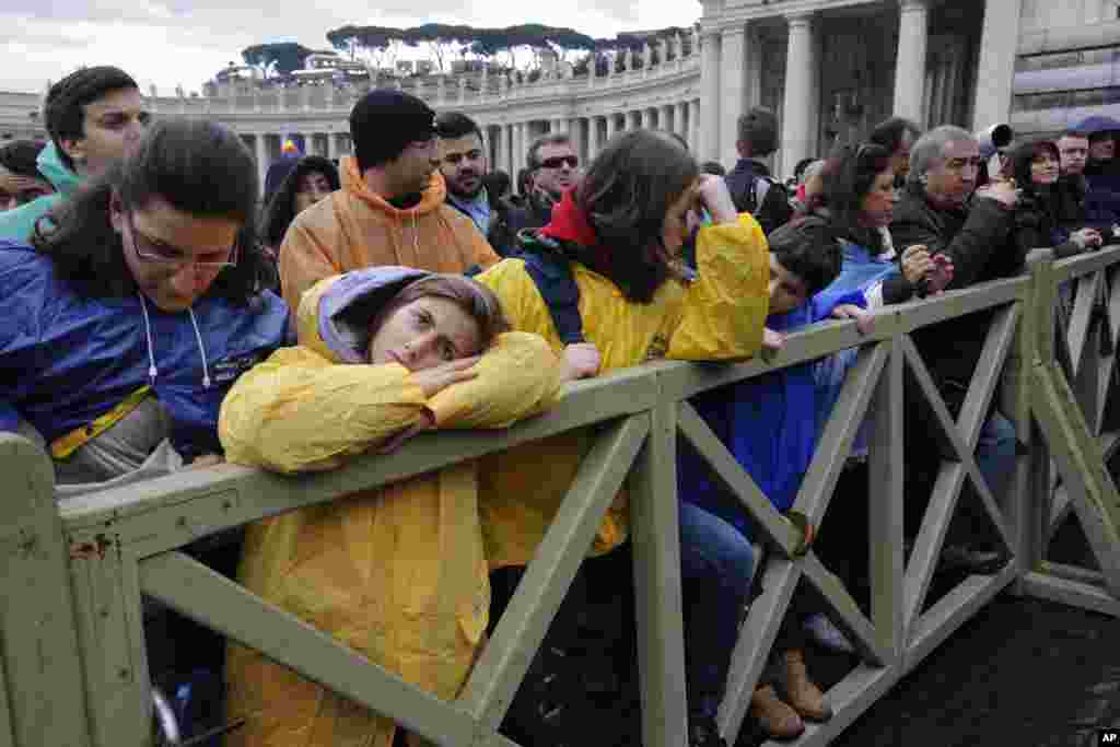 Visitors wait in Saint Peter's Square during the second day of voting, March 13, 2013.