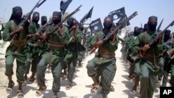 FILE - Al-Shabab fighters march with their weapons during military exercises on the outskirts of Mogadishu, Somalia, Feb. 17, 2011. Missiles fired Feb. 21, 2018, targeted a rickshaw carrying al-Shabab militants near Jamaame, in the southern Lower Juba region, causing several deaths, officials said.