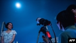 Les gens prennent des photos avant l'éclipse de Lune à Hong Kong le 28 juillet 2018.