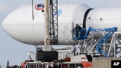 Maintenance is performed by workers on the Falcon 9 SpaceX rocket at launch complex 40 at the Cape Canaveral Air Force Station, Cape Canaveral, Florida, Feb. 9, 2015. 