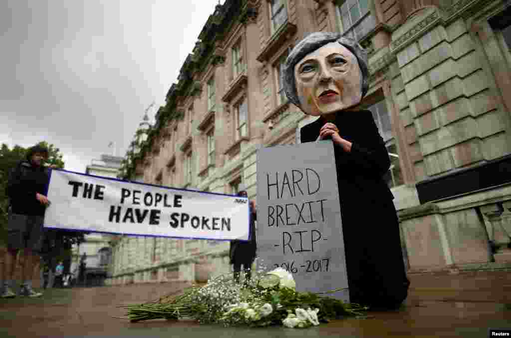 A protester wearing a Theresa May mask is seen the day after Britain's election in London.