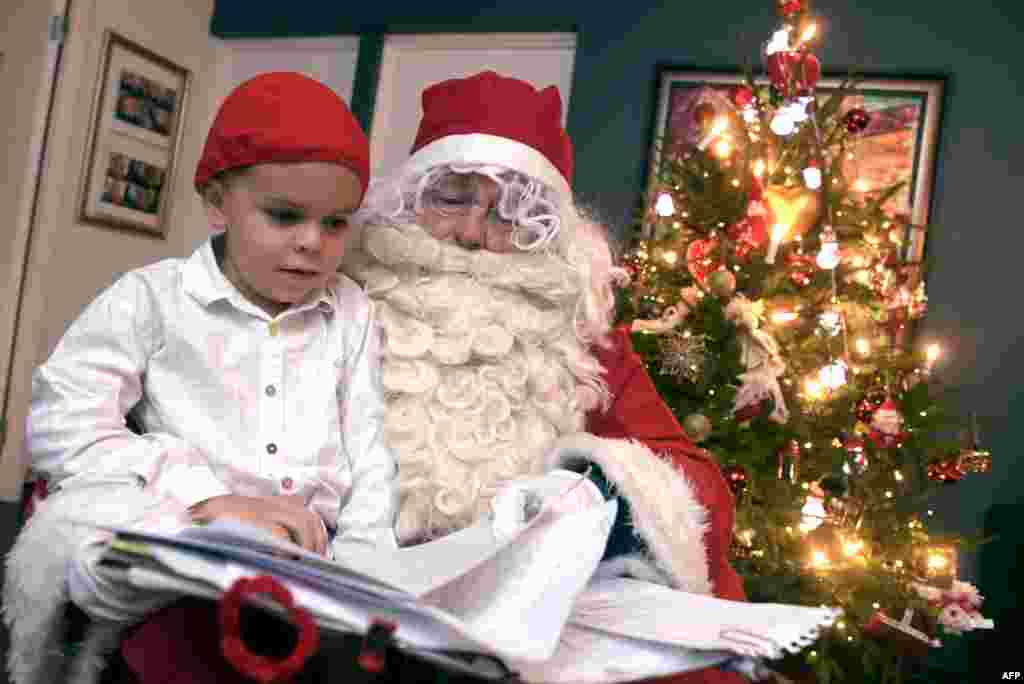 A man dressed as Santa Claus visits and gives Christmas presents at a family's home on the Christmas Eve in Espoo, Finland.