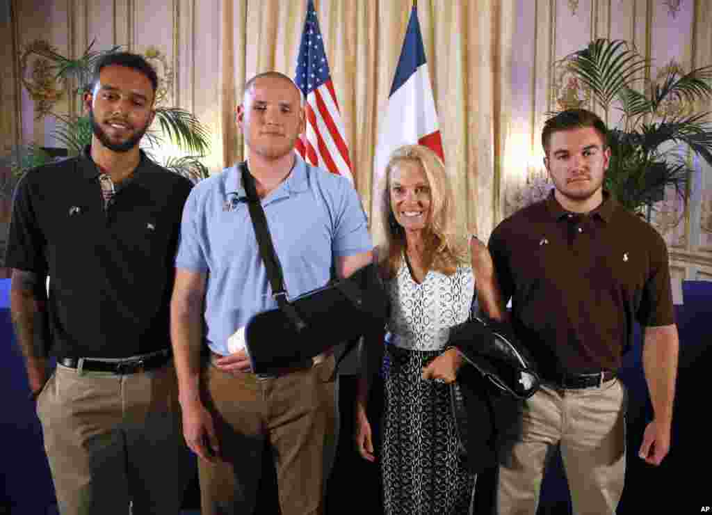 From left, American Anthony Sadler, U.S. Airman Spencer Stone, U.S. Ambassador to France Jane Hartley and U.S. Oregon National Guardsman Alek Skarlatos pose before a news conference at Hartley's residence in Paris, Aug. 23, 2015.