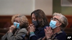 Women pray, June 26, 2021, during a prayer vigil for the victims and families of the Champlain Towers collapsed building in Surfside, Fla., at the nearby St. Joseph Catholic Church in Miami Beach, Fla.