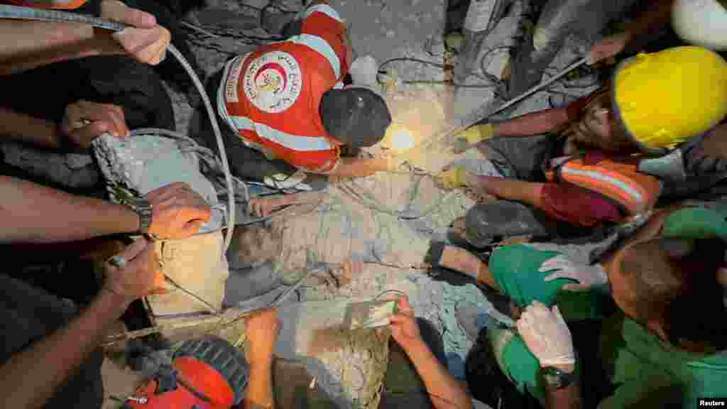Palestinians work to rescue a child from under the rubble following an Israeli strike, amid the Israel-Hamas conflict, in Nuseirat in the central Gaza Strip, Sept. 12, 2024.