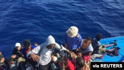 Migrants in a dinghy are rescued by the Libyan coast guard in the Mediterranean Sea off the coast of Libya, Oct. 18, 2019.