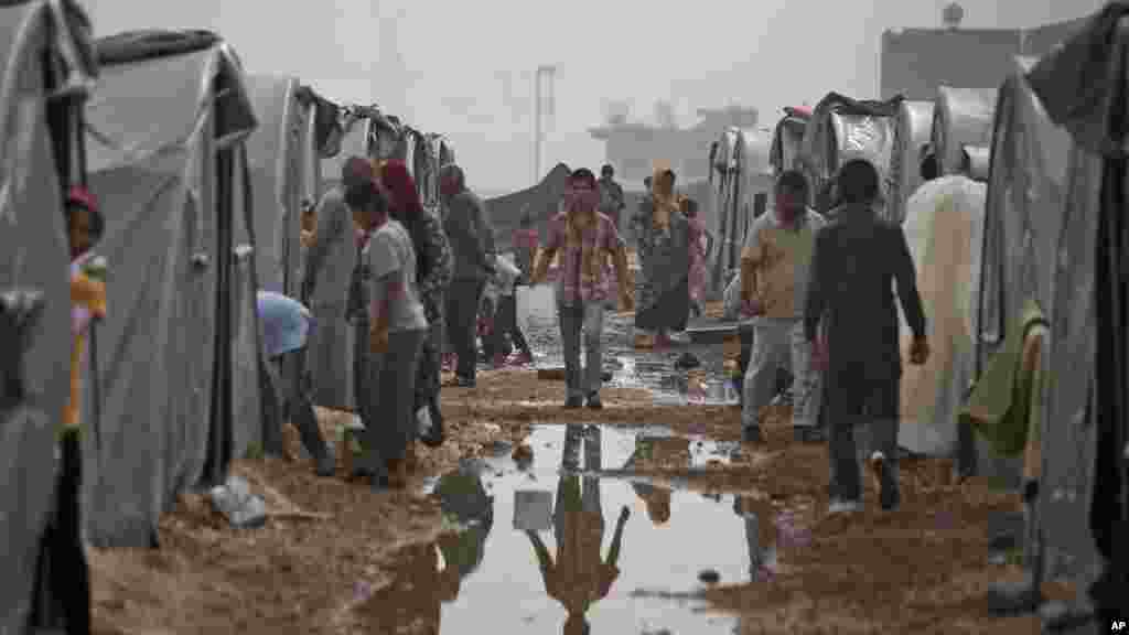 Syrian Kurdish refugees who fled Kobani, go about at a refugee camp in Suruc, on the Turkey-Syria border, Oct. 11, 2014.