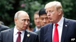 FILE - U.S. President Donald Trump and Russia's President Vladimir Putin talk during a photo session at the APEC Summit in Danang, Vietnam, Nov. 11, 2017. 