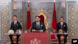 Mfalme wa Morocco Mohammed VI, katikati, akiwa na mtoto wake Moulay Hassan, kushoto, na kaka Prince Moulay Rashid akihutubia Taifa katika hotuba iliyoonyeshwa kwenye TV, kwenye Ikulu ya Kifalme huko Tetouan, Morocco, Jumatatu Julai 29, 2019.
