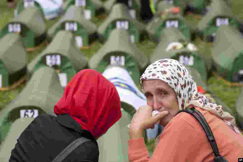 A Bosnian Muslim woman cries near coffins during a memorial ceremony and funeral in Srebrenica. Thousands of people gathered at the Potocari Memorial Center to remember the 175 victims of Europe's worst massacre since World War II.