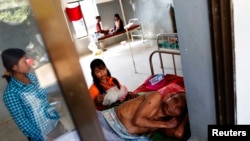A malaria patient is comforted in the only hospital in Pailin, western Cambodia, file photo. 