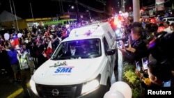 La gente se despide del exmandatario mientras un vehículo del Servicio de Medicina Lega transporta sus restos. En Valdivia, Chile, el 6 de febrero de 2024.