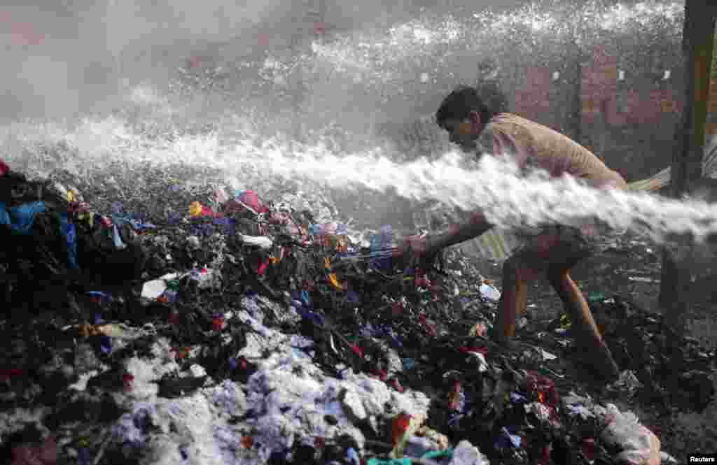 Seorang pria mencoba mencari barang-barang yang masih bisa diselamatkan setelah kebakaran melanda sebuah gudang kapas di Dhaka, Bangladesh.