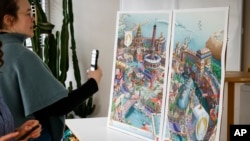 Sejumlah wartawan mengambil gambar dari poster Olimpiade dan Paralimpiade Paris 2024 di sebuah workshop di Ivry-sur-Seine, Paris, pada 20 Februari 2024. (Foto: AP/Thomas Padilla)