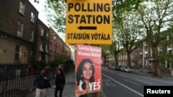 A Pro-Choice poster featuring Savita Halappanavar is placed near a sign for a polling station ahead of a May 25 referendum on abortion law, in Dublin, Ireland, May 23, 2018. 