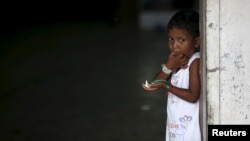A young Rohingya migrant who arrived in Indonesia last week by boat eats a snack at a temporary shelter in Aceh Timur regency near Langsa in Indonesia's Aceh Province, May 26, 2015.