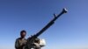 Anggota pasukan Houthi berdiri di belakang senjata dalam aksi protes menentang serangan yang dipimpin AS terhadap target Houthi di Sanaa, Yaman, pada 14 Januari 2024. (Foto: Reuters/Khaled abdullah)