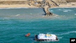 En esta foto proporcionada por el Ejército israelí, la ayuda humanitaria transportada desde un barco de la organización World Central Kitchen (WCK), liderada por los Emiratos Árabes Unidos, llega al espacio marítimo de la Franja de Gaza, el viernes 15 de marzo de 2024.