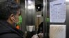 Seorang pria Iran menggunakan tongkat kecil untuk menekan tombol lift di sebuah gedung perkantoran di Teheran, 4 Maret 2020, sebagai langkah pencegahan COVID-19. (Foto: AFP)