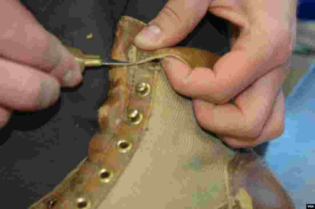 Delicate work to remove the collar which had to be replaced at the Danner factory in Portland, Oregon, Jan. 20, 2014. (Steve Herman/VOA)