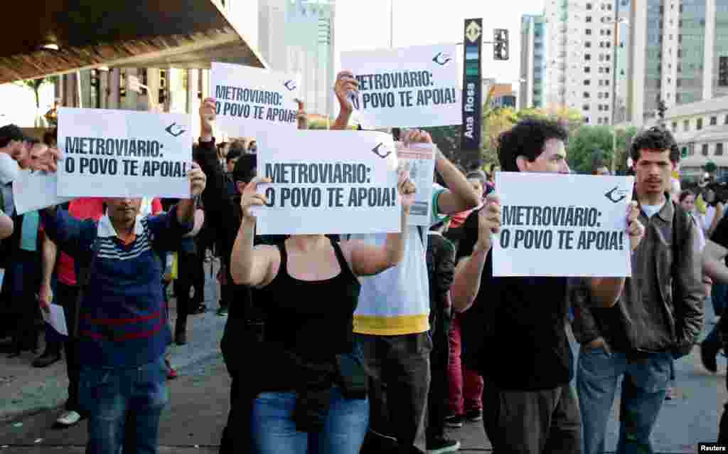 Residents hold up signs that read, "Metro workers: The people support you," outside Ana Rosa subway station during the fifth day of metro workers' strike in Sao Paulo, Brazil, June 9, 2014.