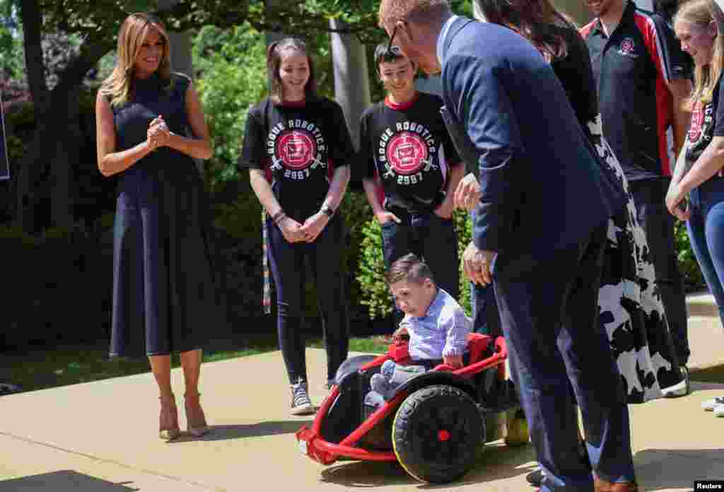 U.S. first lady Melania Trump watches 5-year-old Rocco Zachow-Rodriguez as he rides in a modified wheelchair created by a high school robotics team from Farmington High School in Farmington, Minnesota, May 7, 2019.