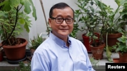 រូបឯកសារ៖ លោក សម រង្ស៊ី អតីត​ប្រធាន​គណបក្ស​សង្គ្រោះ​ជាតិ (CNRP) ដែល​ត្រូវ​បាន​តុលាការ​រំលាយ​ចោល ដែល​កំពុង​រស់នៅ​ភៀសខ្លួន​ក្នុង​ប្រទេស​បារាំង អង្គុយ​នៅ​រានហាល​នៃ​គេហដ្ឋាន​របស់​លោក​ក្នុង​ប្រទេស​បារាំង​នៅ​ថ្ងៃទី ១៩ ខែកក្កដា ឆ្នាំ២០១៨។ (REUTERS/Philippe Wojazer)