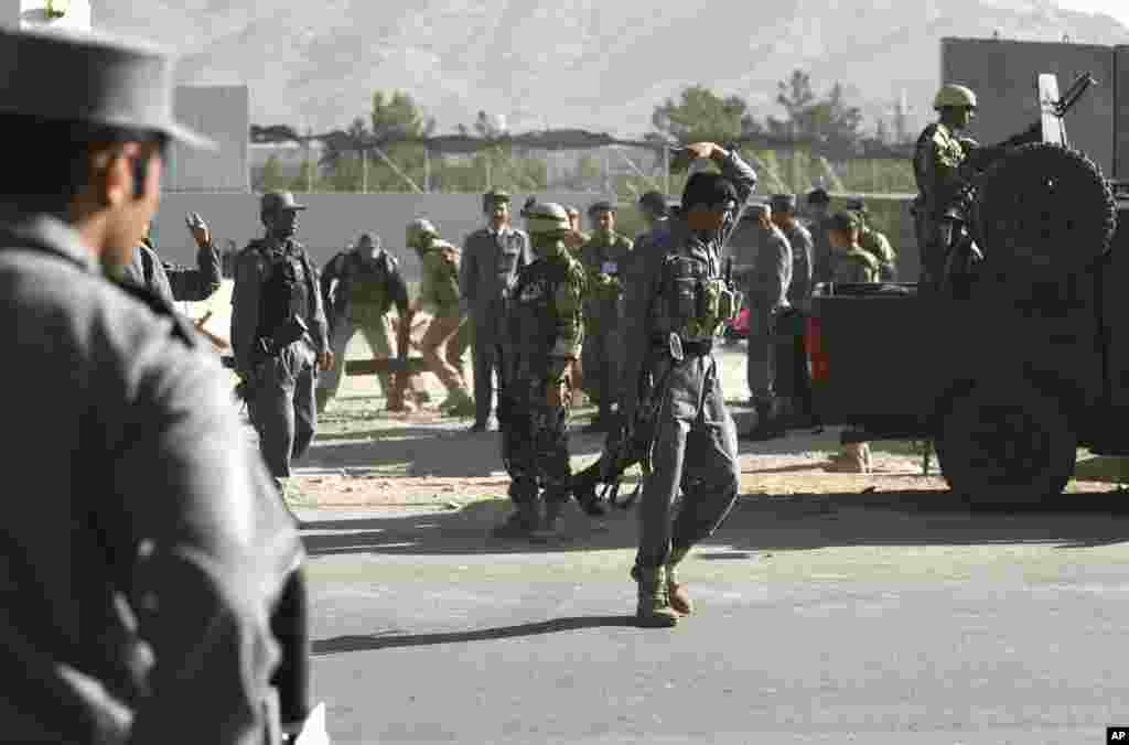 Afghan and foreign security forces inspect the site of a suicide attack at the deputy counter narcotic compound in Kabul, Afghanistan, July 22, 2014. 