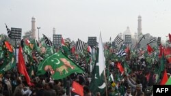 Para pendukung Gerakan Demokratik Pakistan (PDM), mengibarkan bendera dalam unjuk rasa anti-pemerintah di Lahore, Ibu Kota Pakistan, Minggu, 13 Desember 2020. (Foto: Arif Ali/AFP)