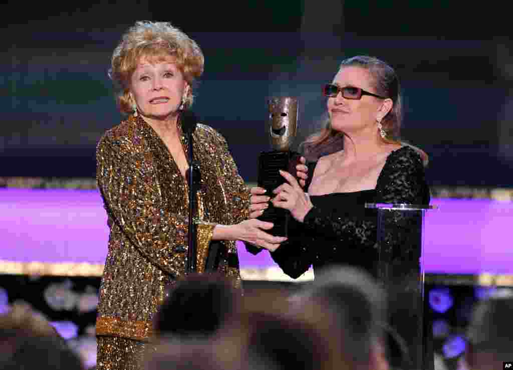 Carrie Fisher presents Debbie Reynolds with the Screen Actors Guild life achievement award at the 21st annual Screen Actors Guild Awards at the Shrine Auditorium, Jan. 25, 2015, in Los Angeles.