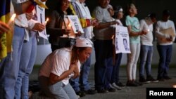 ARCHIVO - La madre de un venezolano detenido durante las protestas contra los resultados de las elecciones presidenciales reza durante una vigilia con velas en la Universidad Central de Venezuela en Caracas, Venezuela, el 17 de diciembre de 2024. 