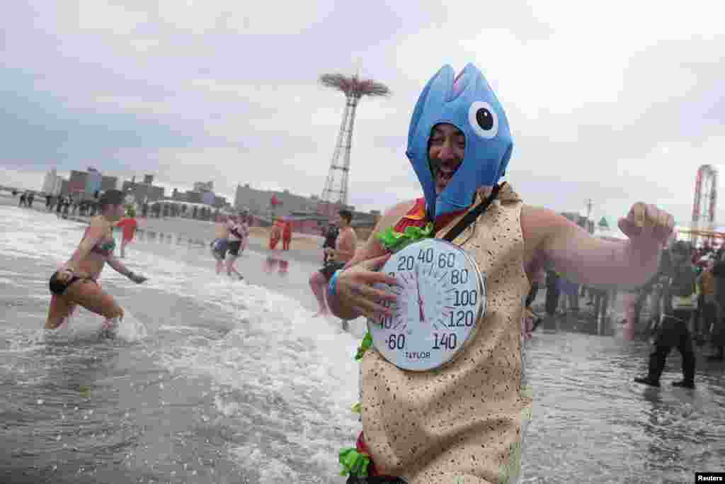 A costume wearing bather runs into the sea during the annual Polar Bear swim marking New Year’s Day, at Coney Island, in New York City.