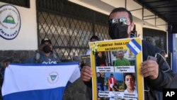 Un activista sostiene un cartel con un mensaje que lee: “Liberen a los sacerdotes” e imágenes del clero encarcelado por el gobierno de Daniel Ortega, durante una protesta frente a la embajada de Nicaragua, en San José, Costa Rica, el 20 de febrero de 2023