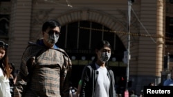 Para pejalan kaki mengenakan masker di stasiun Flinders Street di Melbourne, Victoria, Australia, saat merebaknya virus korona, 29 Januari 2020. (Foto: dok).