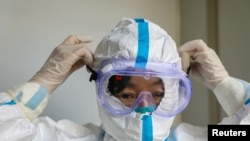 Seorang dokter memakai kacamata pelindung sebelum memasuki bangsal isolasi di sebuah rumah sakit, menyusul pecahnya coronavirus baru di Wuhan, provinsi Hubei, Cina. (Foto: Reuters)