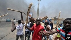 People holding wooden and metal sticks demonstrate in Nigeria's northern city of Kano where running battles broke out between protesters and soldiers on April 18, 2011 as President Goodluck Jonathan headed for an election win