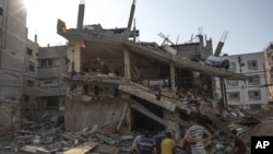 Palestinos inspeccionan su casa que fue alcanzada por un ataque aéreo israelí en la ciudad de Gaza, el lunes 8 de agosto de 2022. 