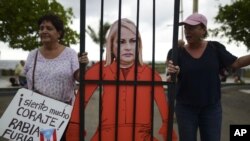 Manifestantes sostienen una imagen de la gobernadora de Puerto Rico, Wanda Vázquez, con ropa de presidiaria durante una protesta porque la ayuda para los afectados por huracanes permanecía en depósitos. en San Juan, Puerto Rico, 23 de enero de 2020.