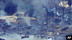 FILE- An illegal oil refinery is pictured in Ogoniland, outside Port Harcourt in Nigeria's Delta region, in March 2011.