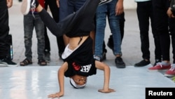A Palestinian boy performs breakdance at a street in Nusseirat refugee camp in central Gaza Strip, October 14, 2022. (REUTERS/Ibraheem Abu Mustafa)