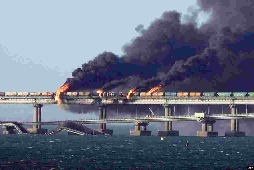 Black smoke billows from a fire on the Kerch bridge that links Crimea to Russia, after a truck exploded, near Kerch, Oct. 8, 2022.