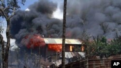 Smokes and flames billow from burning buildings in Sittwe, capital of Rakhine state in western Burma, where sectarian violence is ongoing, June 12, 2012.