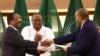 L'ancien président kenyan Uhuru Kenyatta applaudit le représentant du gouvernement éthiopien Redwan Hussien et le délégué du Tigré Getachew Reda, à Pretoria, le 2 novembre 2022.