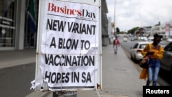 Une femme passe devant un panneau affichant un titre en une d'un quotidien sud-africain pendant l'épidémie de coronavirus à Johannesburg, en Afrique du Sud, le 8 février 2021.